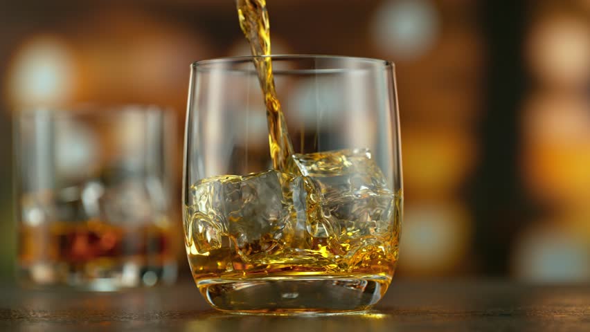 Super slow motion of pouring whisky into glass . Filmed on high speed cinema camera , speed ramp , 1000 fps