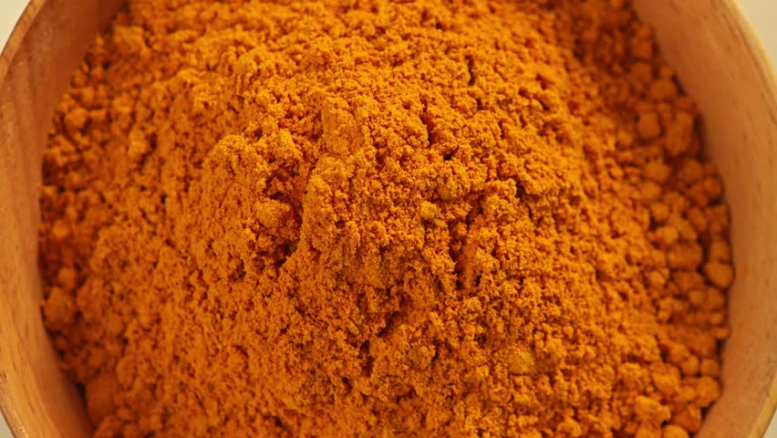 turmeric powder on wooden bowl