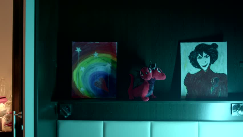 An eyecatching and vibrant shelf showcases abstract art alongside a plush toy and a uniquely styled painting creative works on the shelf in Kostanay in the evening