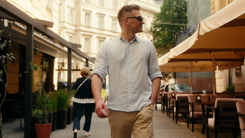 Caucasian confident man businessman stylish guy rich traveler happy smiling male going street city cafes walking in fashion sunglasses tourist explore town summer holiday vacation travel insurance