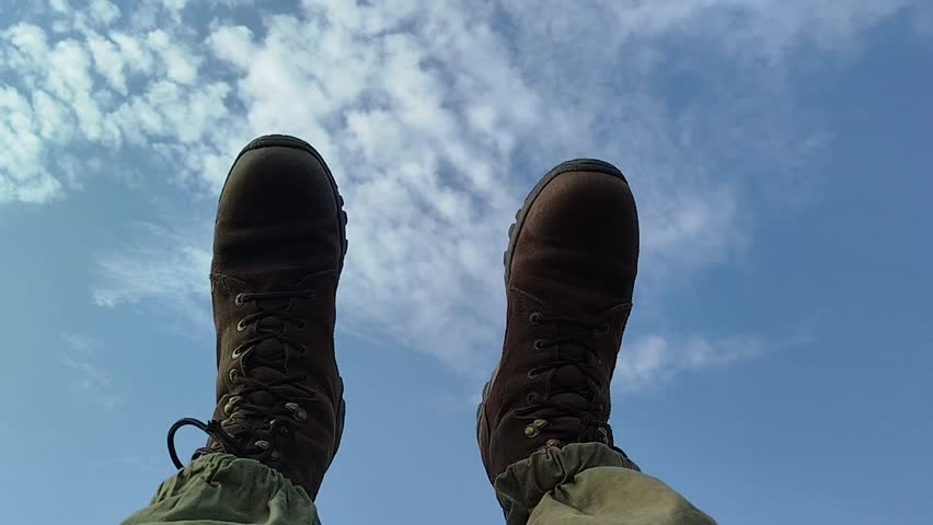 A man in brown boots walks through the sky.