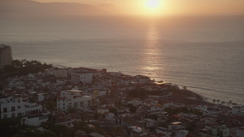 The sunset over the beaches of Puerto Vallarta as seen from Mirador de la Cruz popular scenic viewpoint and tourist attraction in Puerto Vallarta, located in Jalisco Mexico