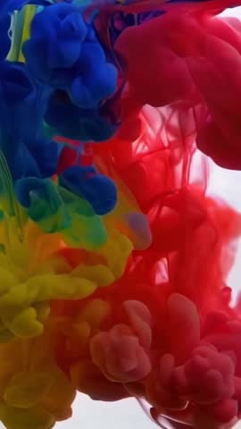 Bold blue, red, and yellow ink swirls blend underwater, forming a striking and colorful abstract art scene.