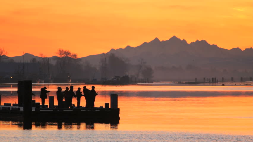 Fishermen at Dawn. Sport fishermen line up on the floating dock in Steveston Harbor trying their luck in the morning. Richmond, British Columbia, Canada.
