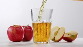 Apple juice or cider is pouring from a bottle into a glass. Fresh drink with apples and pear on an old kitchen table.  - Powered by Shutterstock - Get 15% off with code: PIKWIZARD15
