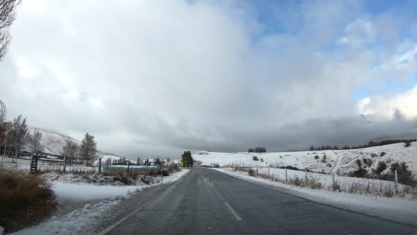 Scenic winter drive along Crown Range Road between Queenstown and Wanaka, Cardrona Oatgo New Zealand, Snow-covered mountains and winding roads serene alpine landscape