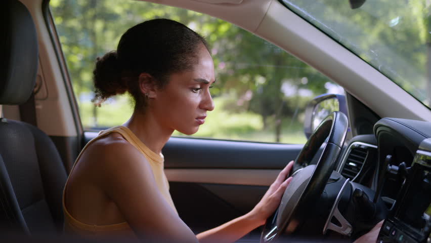 Angry African American woman trying start car auto automobile ignition stall problem breakdown driver transport late female girl crash repair vehicle service annoyed businesswoman steering business