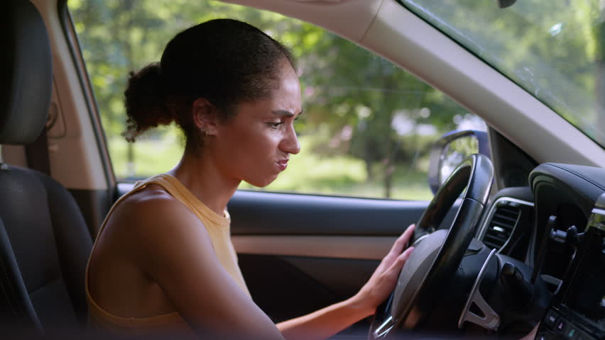 Angry African American woman trying start car auto automobile ignition stall problem breakdown driver transport late female girl crash repair vehicle service annoyed businesswoman steering business