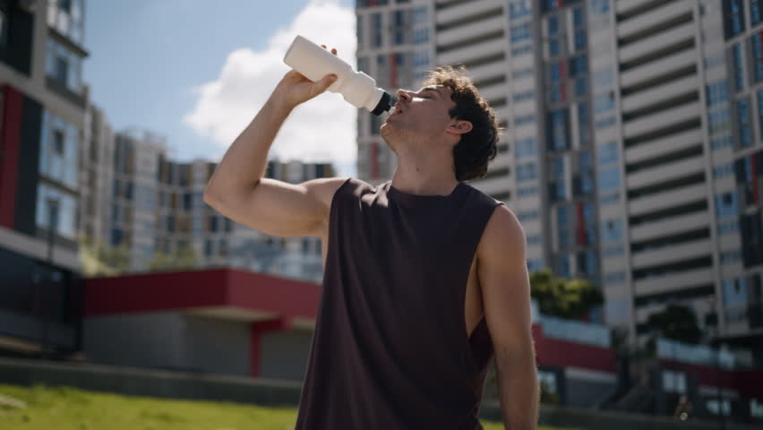 Caucasian man athlete male guy sport drinking bottle water refresh workout city outside fitness runner healthy sportsman thirsty healthcare wellness diet loss weight drink relaxing training lifestyle