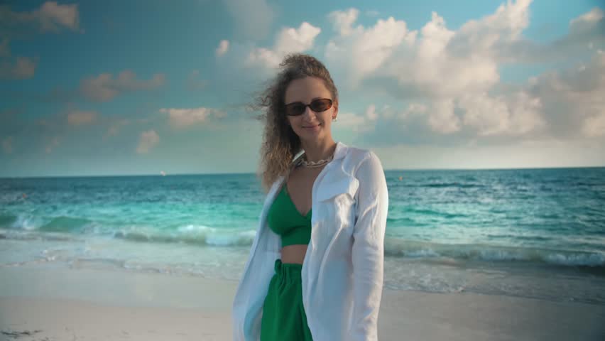 Attractive girl walking along seaside.Curly woman enjoy vacation at caribbean sea view.Holidays at summer. High quality 4k footage