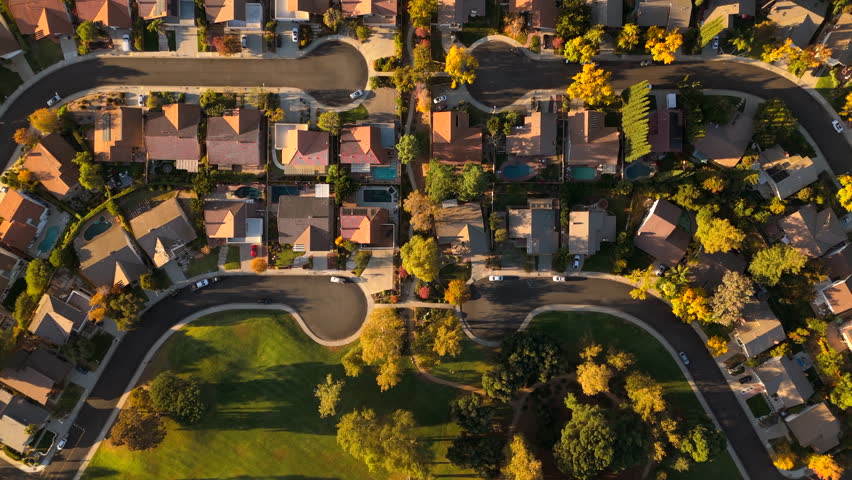 Stunning aerial image beautifully captures a serene Los Angeles suburb, showcasing picturesque homes nestled among vibrant trees, all bathed in the warm golden light of the sunset atmosphere