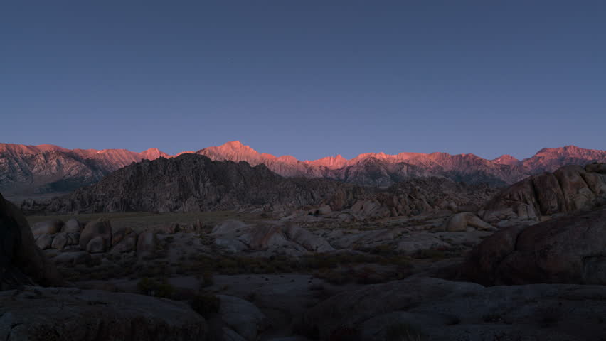 Timelapse transition from moonset to sunrise over Sierra Nevada Mountains in California, USA