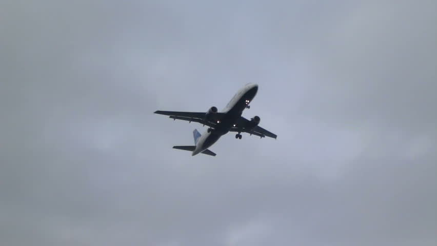 Commercial passenger airplane flying overhead on cloudy morning, with sound.