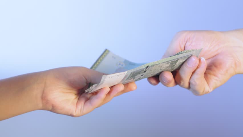Businessman wearing a suit is giving money to another person on a blue background