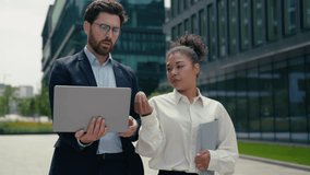 Multiracial colleagues two multiethnic business businesspeople Caucasian man businessman guy male talking discuss arguing African American woman businesswoman female girl in city walking laptop task - Powered by Shutterstock - Get 15% off with code: PIKWIZARD15