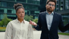 Two sad upset multiethnic coworkers business colleagues managers Caucasian man businessman male guy African American woman businesswoman female girl failure in city spread hands sides shrug shoulders - Powered by Shutterstock - Get 15% off with code: PIKWIZARD15