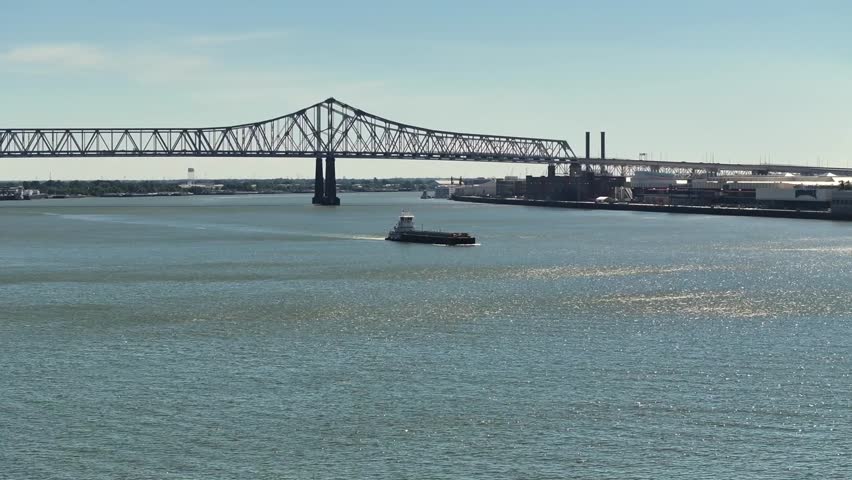 Pushboat and barge coasting along the Mississippi River near New Orleans