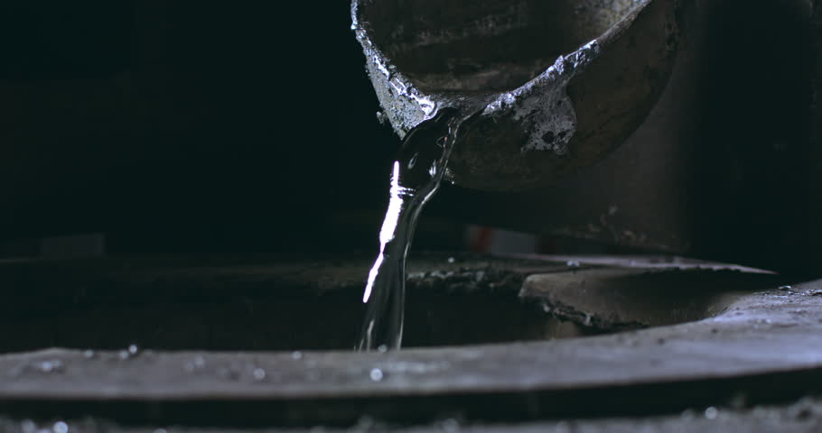 Super slow motion close-up of aluminum melting in foundry at 1000 fps. Raw metal is heated in furnace until molten, then kept at  stable temperature for pouring