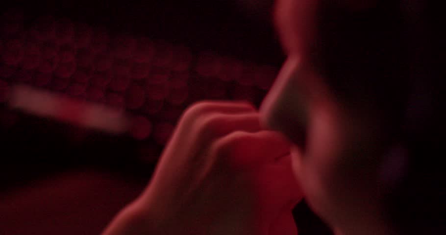 Close-up of fingers pressing the keys of a keyboard. Closeup of person deeply immersed in digital task, illuminated by dramatic captivating red lighting. Interaction with technology in a digital work