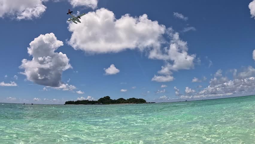 Sea plane airplane flying over tropical island in the maldives