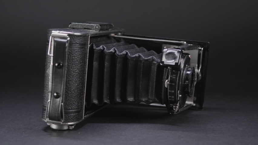 Old antique vintage camera against black backdrop