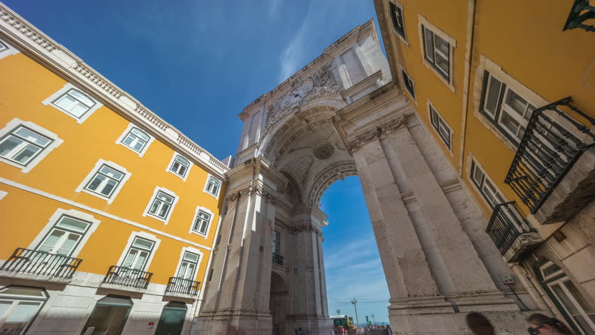 Rua Augusta Arch (Arco da Rua Augusta) timelapse hyperlapse on Praca do Comercio. Historic stone art monument with clock, ornaments and old tourist landmark attraction in Lisbon, Portugal, Europe.