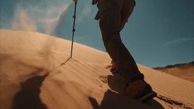 Hiker walks uphill at sand dune. Close up video of hikers legs is climbing uphill at sandy slope with hiking poles - Powered by Shutterstock - Get 15% off with code: PIKWIZARD15