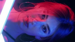 Vertical video. Color light face. Cyberpunk beauty. Futuristic party. Pink blue neon glow woman in smoke white LED lamp illumination on dark background. - Powered by Shutterstock - Get 15% off with code: PIKWIZARD15