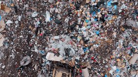A massive landfill stretches across the horizon as heavy machinery struggles to manage the towering piles of waste. The environment is cluttered with discarded items and debris. - Powered by Shutterstock - Get 15% off with code: PIKWIZARD15