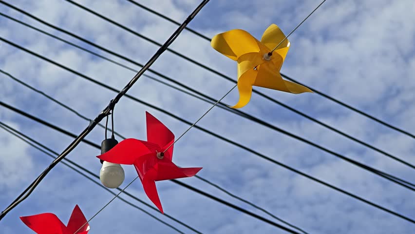 Pinwheel or windmill rotate from windy on sky background.