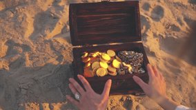 unrecognizable person close-up hands open treasure chest gold coins glowing in sun light. Fantasy thief pirate finds treasure wooden box old style full of rich jewelry. Nature sand desert island 4k. - Powered by Shutterstock - Get 15% off with code: PIKWIZARD15