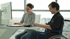 Colleagues business people woman man in chair for people with disability working on office. Startup business group team working together. Corporate professional team discussing project ideas - Powered by Shutterstock - Get 15% off with code: PIKWIZARD15