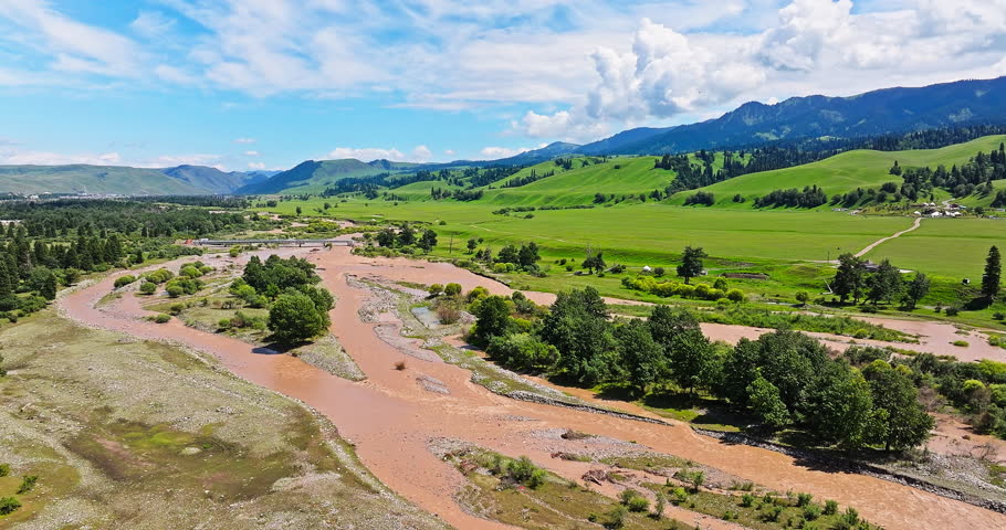 Aerial video of Nalati grasslands, curved river and green grassland with mountain natural landscape in Xinjiang. Famous grassland pasture scenery in China.