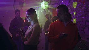 Couple with smartphones standing club ignoring each other under disco ball closeup. Man looking at woman using cellphone in vibrant nightclub. Two clubbers with phones meeting on vibrant dance floor. - Powered by Shutterstock - Get 15% off with code: PIKWIZARD15
