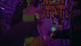 Woman feeling lonely in party at neon light club. Sad beautiful girl looking smartphone sitting at graffiti wall nightclub alone. Serious female clubber resting in disco bar atmosphere with cellphone. - Powered by Shutterstock - Get 15% off with code: PIKWIZARD15