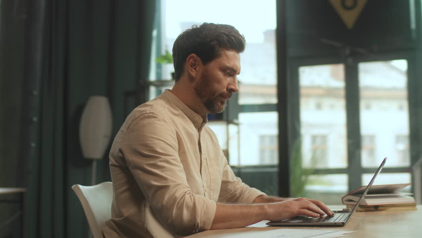 Handsome man sitting at desk open laptop look on screen typing in office. Work time. Camera moving around. 360 Degree - Powered by Shutterstock - Get 15% off with code: PIKWIZARD15