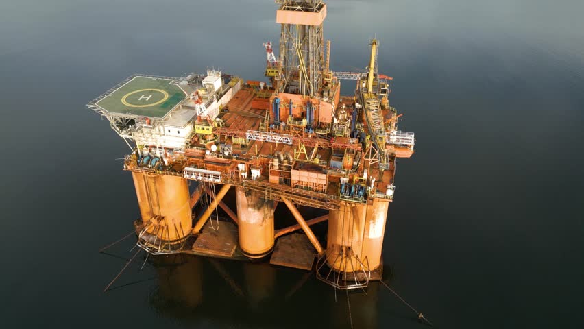 center offshore oil rig drilling platform parked estuary significance energy production engineering circling aerial shot view footage operational orders marine