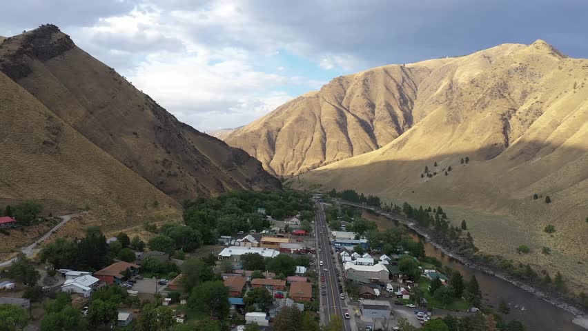 Aerial drone shot of Salmon river and town of Riggins Idaho. Drone flying straight forward at sunset.
