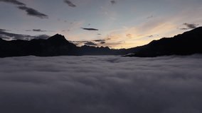 An aerial view over Lake Walensee in Switzerland, completely enveloped by a thick layer of fog and clouds. The mountain peaks rise above, silhouetted against the dawn sky. - Powered by Shutterstock - Get 15% off with code: PIKWIZARD15
