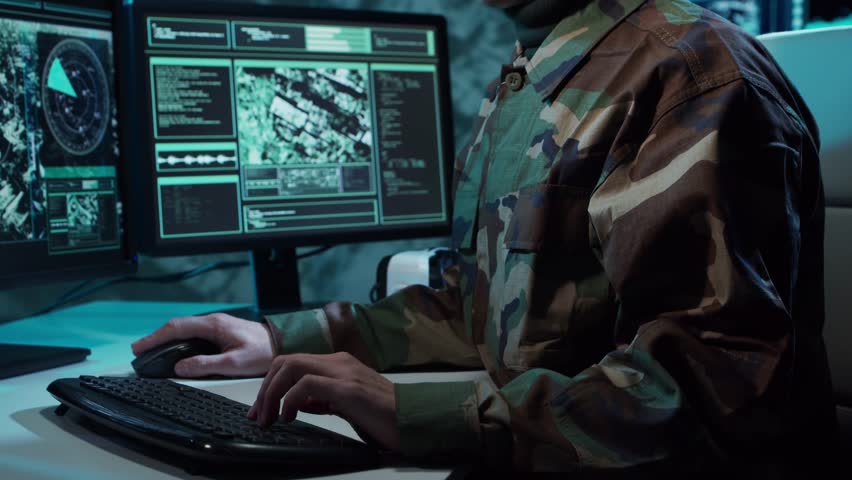 Military soldier operating advanced technology in a command center.
