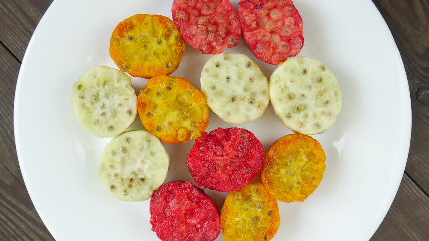 Cut prickly pear cactus fruits on a plate.