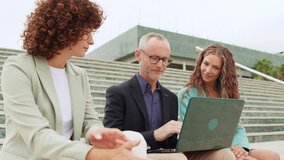 Group of businesspeople collaborating outdoors with laptop - Powered by Shutterstock - Get 15% off with code: PIKWIZARD15