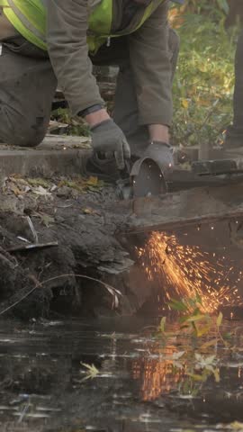 male worker cutting metal with grinding machine tool