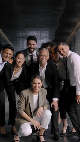 Vertical. Excited funny multi-ethnic staff people business team stand in office looking at camera. Happy diverse professional colleagues group celebrate success win victory reward at corporate party
