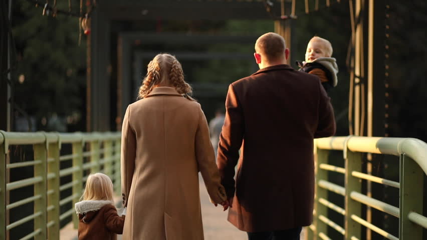 a beautiful family in stylish clothes in an autumn park