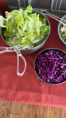 A vibrant salad bar with a variety of fresh ingredients, including lettuce, broccoli, cucumber, cherry tomatoes, red cabbage, crab sticks, peaches, mushrooms, corn, cheese cubes, olives, and bean spro