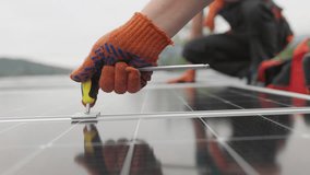 Technicians installing solar panels on metal stand. Workers installing solar panels on the roof of a house. Close-up Installation, Connection and mounting of solar panels. Workers fasten solar panels. - Powered by Shutterstock - Get 15% off with code: PIKWIZARD15
