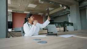 Indian female doctor examining X-ray for diagnosis at desk - Powered by Shutterstock - Get 15% off with code: PIKWIZARD15