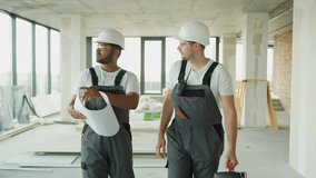 Indian and Caucasian builders walking with tools at construction site and planning a new office renovation - Powered by Shutterstock - Get 15% off with code: PIKWIZARD15