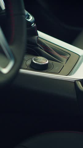 Vertical video Close up of car interior gearbox gear shift, transmission control panel and buttons activating different vehicle functions. Panning shot of vehicle automatic gearbox control buttons